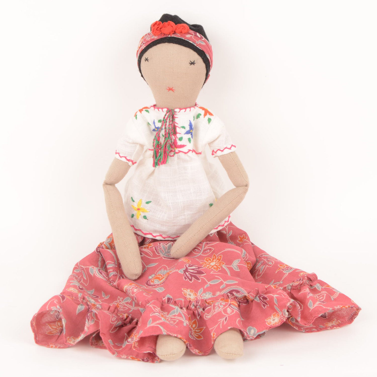 Frida, a handcrafted Afghan doll with vibrant floral patterns and intricate embroidery, symbolizing resilience and empowerment.